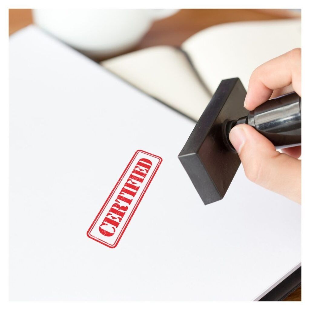 a paper being stamped with a red certified stamp