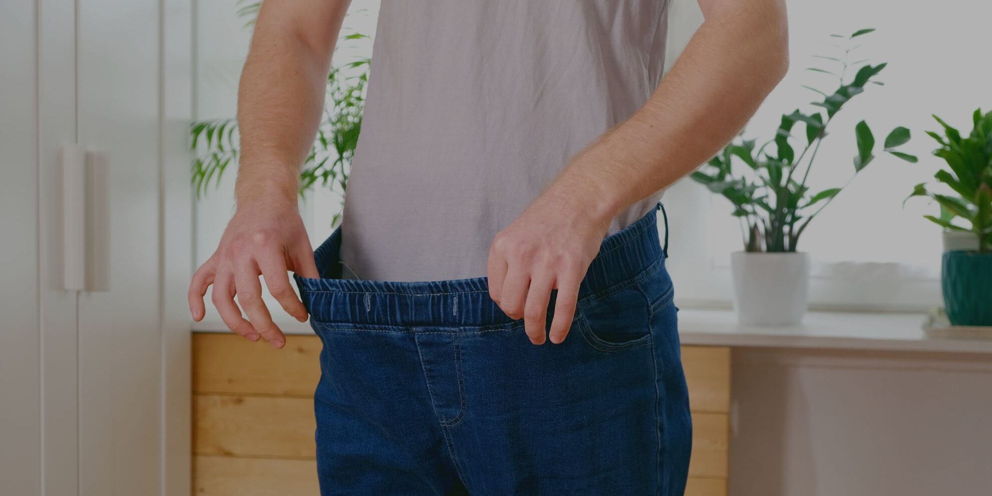 someone stretching their pants after losing weight