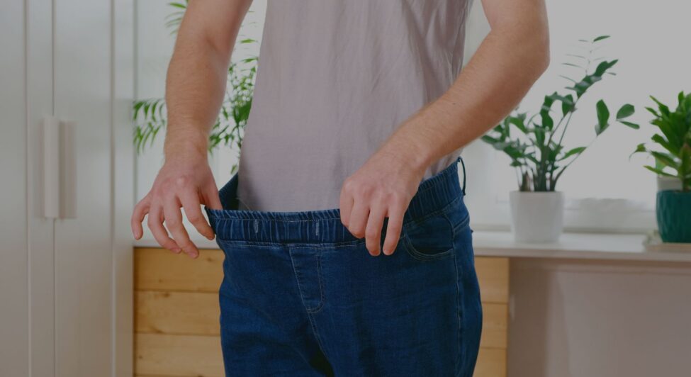 someone stretching their pants after losing weight